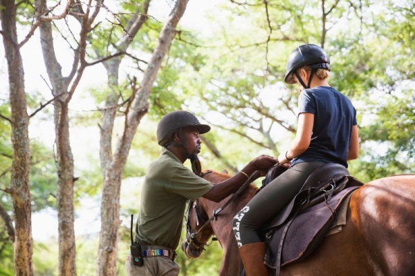 Man teaching child to horse ride
