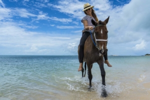 Woman riding horse bareback on beach