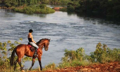 a painting of a woman riding a horse in the floodplain of a river
