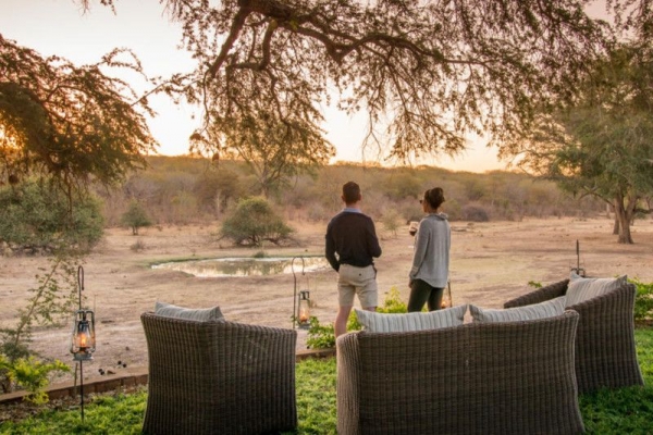 People overlooking waterhole from lodge in Zimbabwe