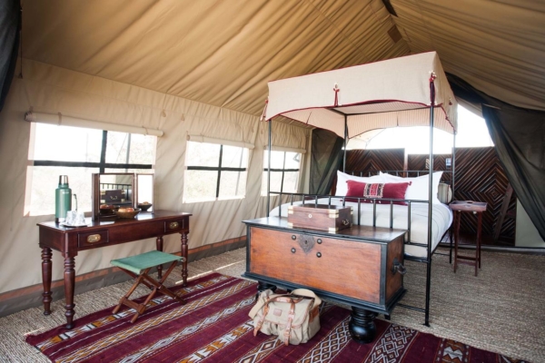 Interior of lusuxry tented camp with explorer style canopy bed