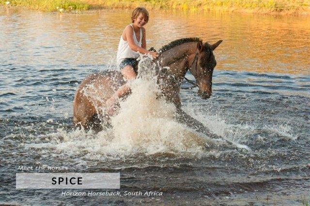 Boy riding horse splashing in water