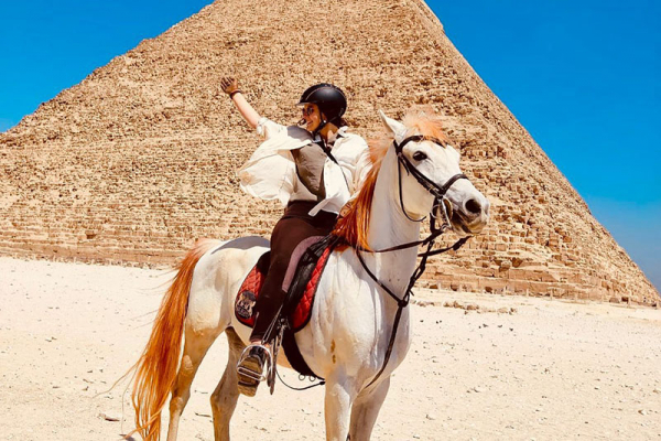 Girl on horse in front of Pyramids of Giza