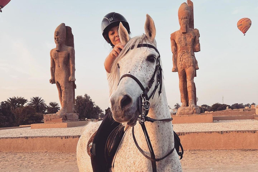 Girl on white horse in Egyptian desert