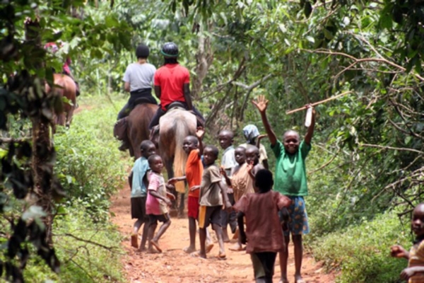 Ugandan kids following the horses on safari
