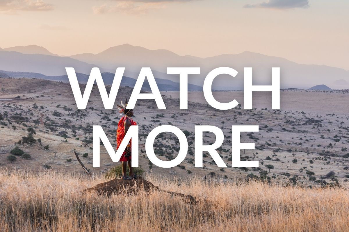 maasai tribesman standing on an old ant mound looking over the kenyan plains