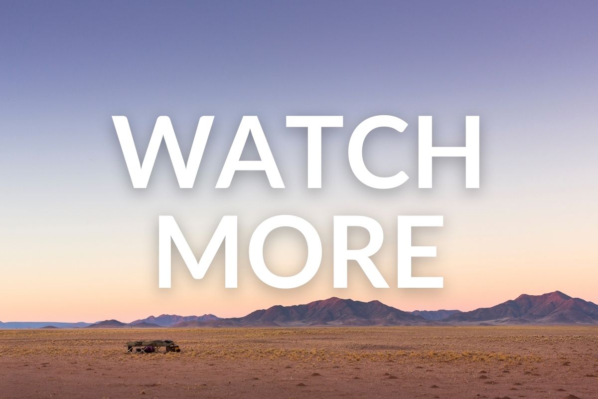 camping equipment set up on a vast plain of desert in namibia with mountains in the background